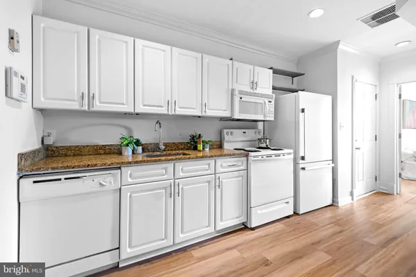 a kitchen with white cabinets and white appliances