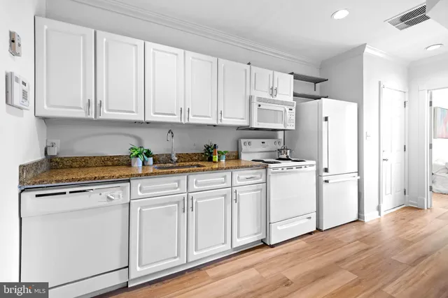 a kitchen with white cabinets and white appliances