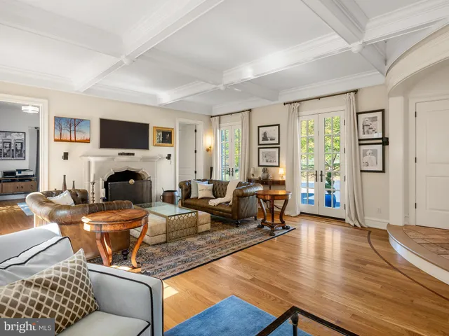 a view of a dining room and livingroom with furniture wooden floor a chandelier