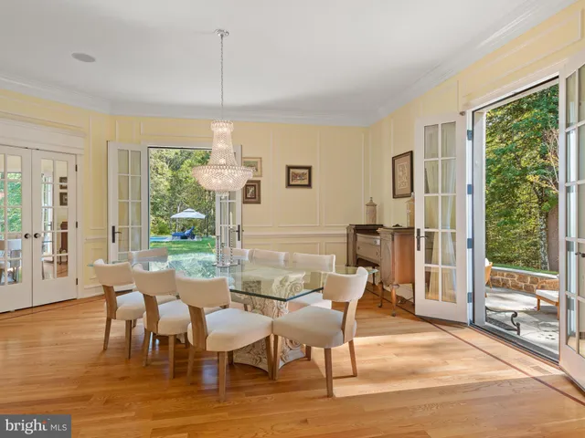 a open kitchen with stainless steel appliances granite countertop a stove a refrigerator a oven a sink with a dining table and chairs