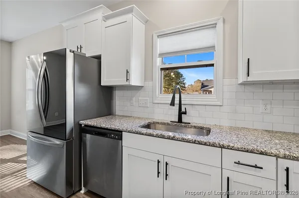 a kitchen with granite countertop a sink stainless steel appliances and cabinets