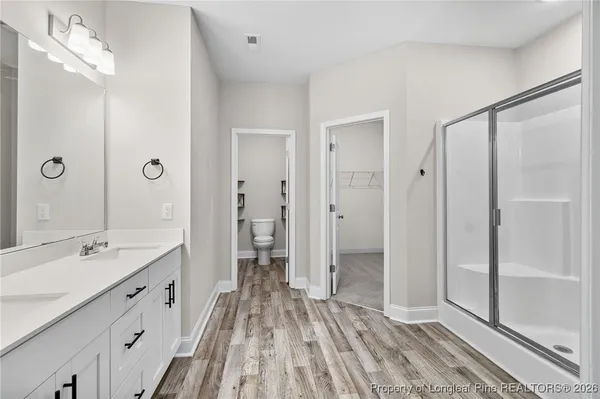 a spacious bathroom with a double vanity sink a mirror and a shower