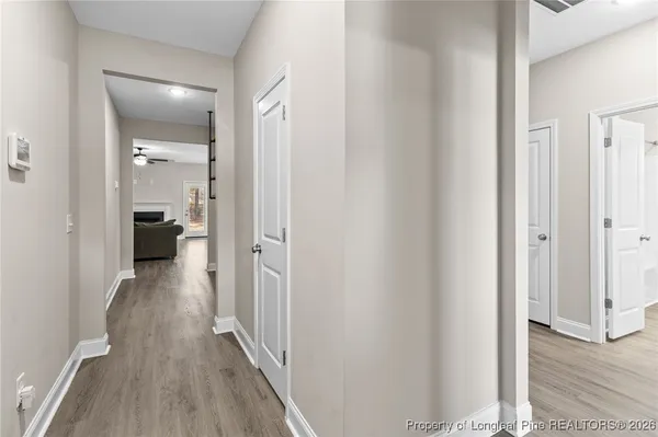 a view of a hallway with wooden floor and closet