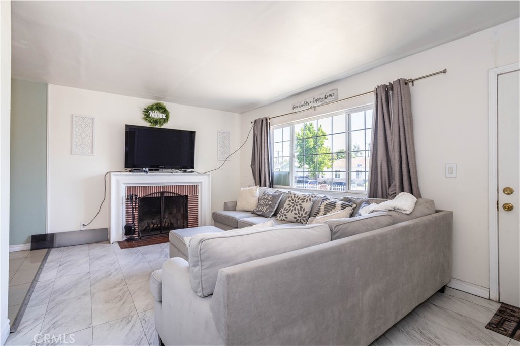 13655 Chase Street Arleta, CA 91331 - Photo 5 of 34 a living room with furniture a fireplace and a flat screen tv