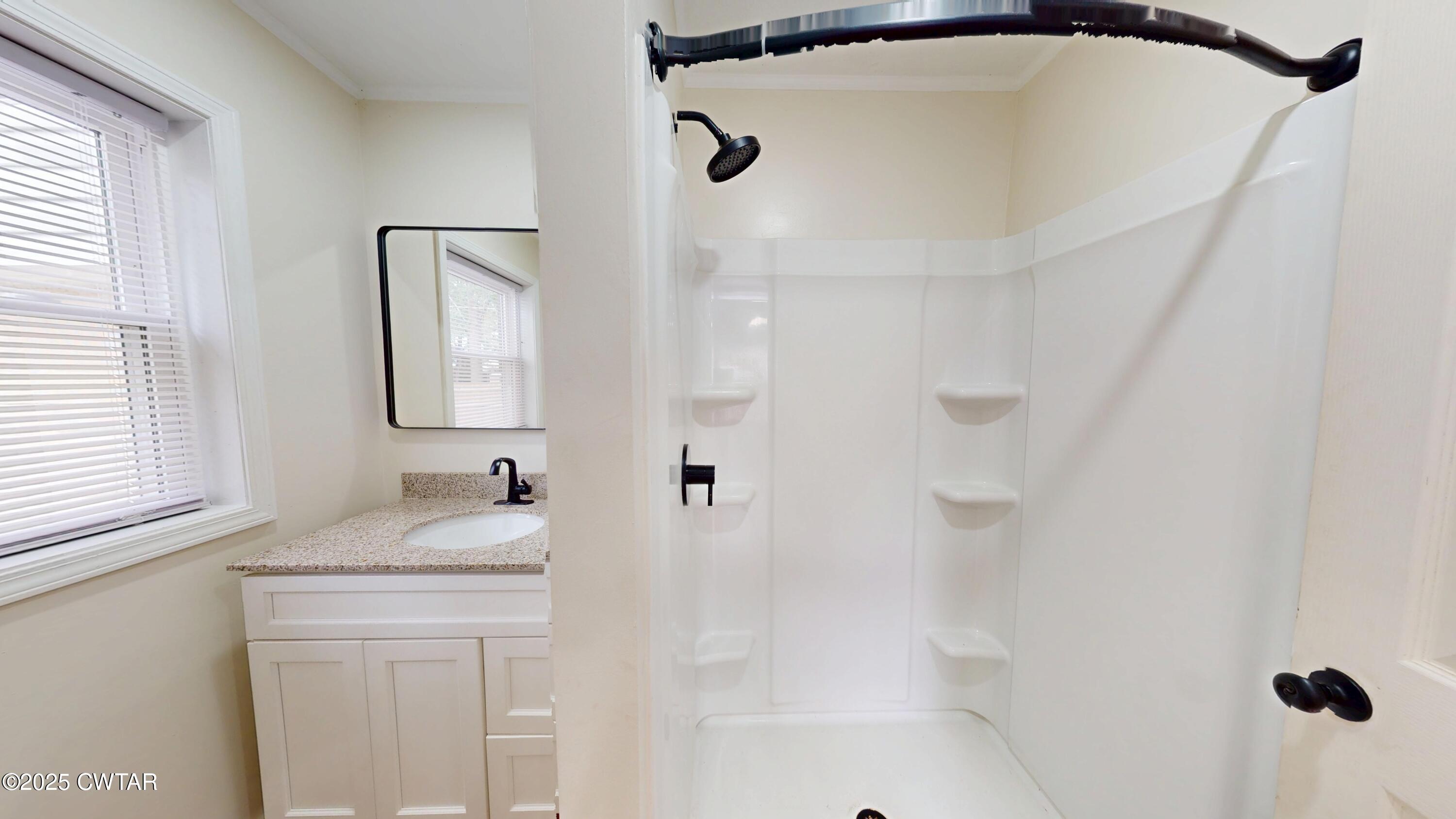 712 West Main Street Newbern, TN 38059 - Photo 12 of 27 a bathroom with a granite countertop sink a mirror and shower