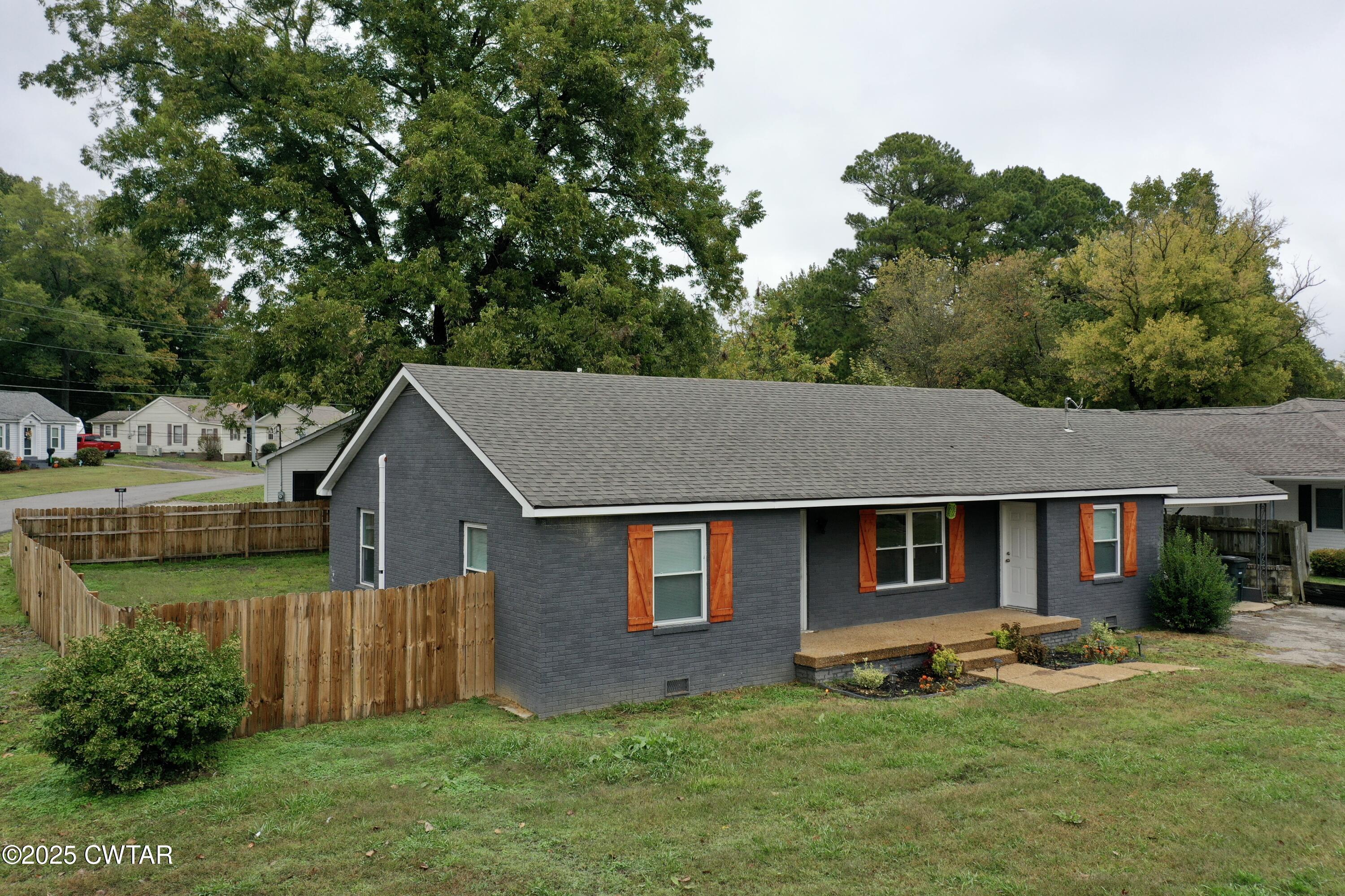 712 West Main Street Newbern, TN 38059 - Photo 20 of 27 a aerial view of a house next to a big yard and large trees
