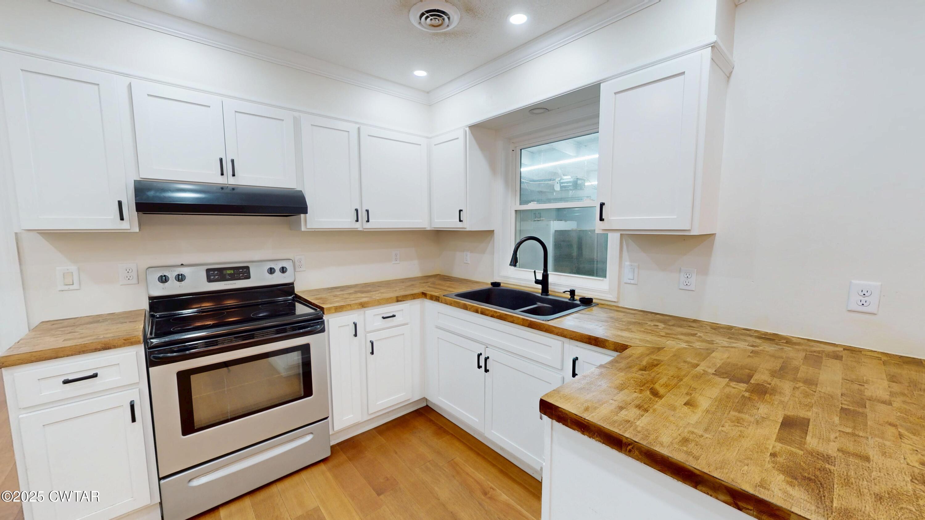 712 West Main Street Newbern, TN 38059 - Photo 5 of 27 a kitchen with granite countertop a stove sink and cabinets