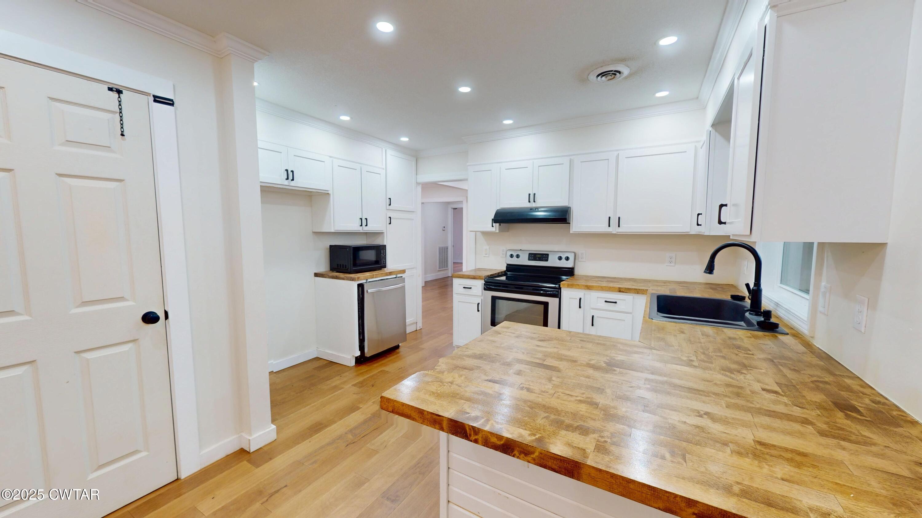 712 West Main Street Newbern, TN 38059 - Photo 6 of 27 a kitchen with stainless steel appliances granite countertop a refrigerator and a sink