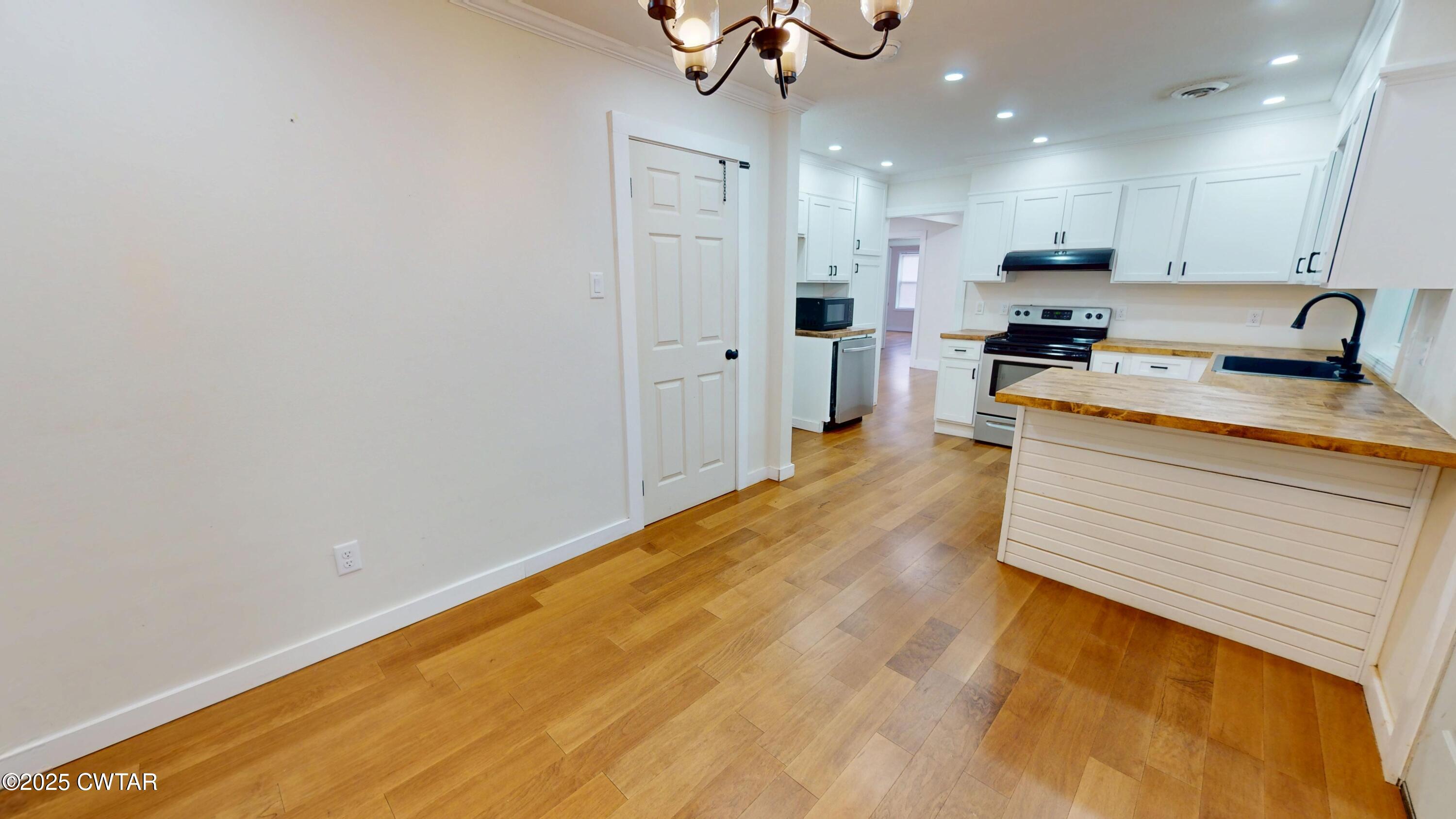 712 West Main Street Newbern, TN 38059 - Photo 8 of 27 a large kitchen with stainless steel appliances a large counter top a stove and a refrigerator with wooden floor