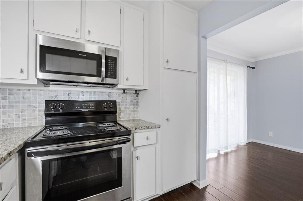 4266 Roswell Road Northeast, Unit E4 Atlanta, GA 30342 - Photo 11 of 24 a kitchen with stainless steel appliances a stove microwave and cabinets