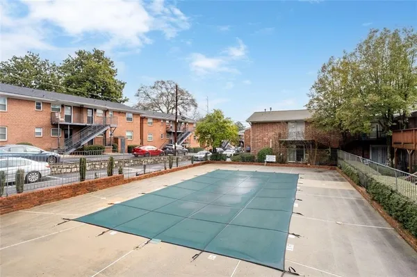 a view of a brick house with a yard and large trees