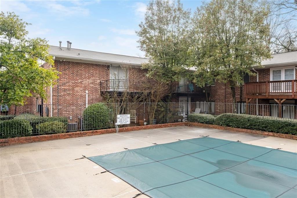 4266 Roswell Road Northeast, Unit E4 Atlanta, GA 30342 - Photo 20 of 24 a view of a brick house with a yard and large trees