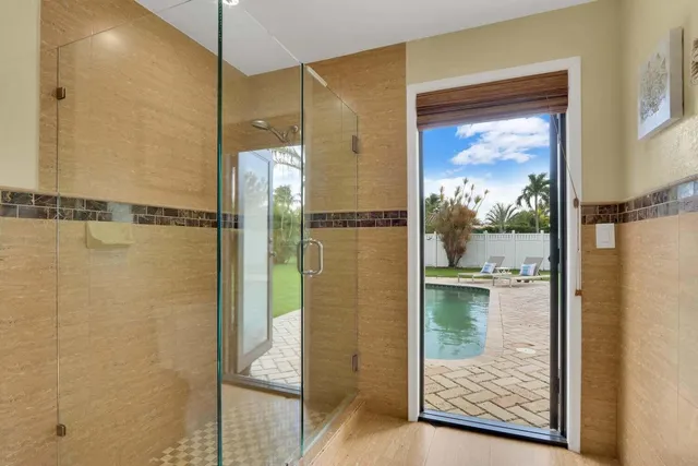 a bathroom with a glass shower door and a window