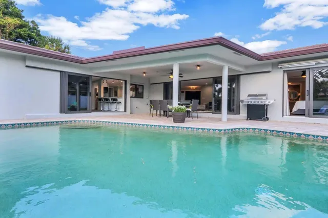 a swimming pool with outdoor seating and yard