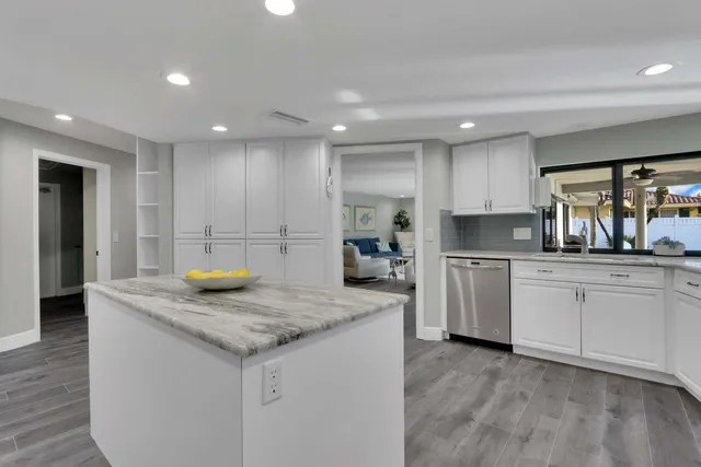 a kitchen with a sink a stove a refrigerator and white cabinets