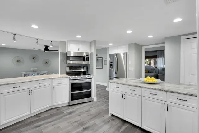 a kitchen with white cabinets and stainless steel appliances