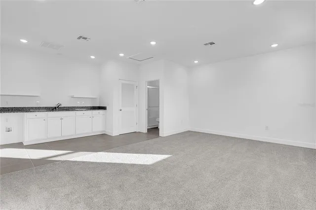 a bathroom with a granite countertop sink and a toilet