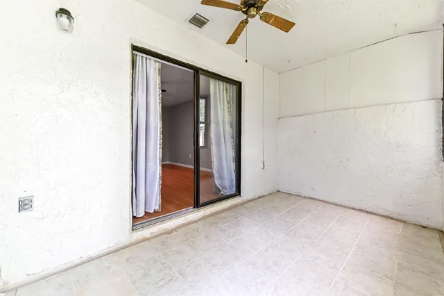 an empty room with a ceiling fan and a window