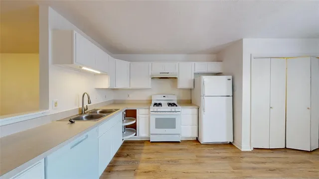 a view of a kitchen with wooden floor and electronic appliances