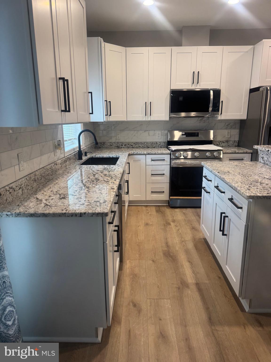 10342 Friendship Road Berlin, MD 21811 - Photo 12 of 28 a kitchen with stainless steel appliances granite countertop a stove a sink and a microwave