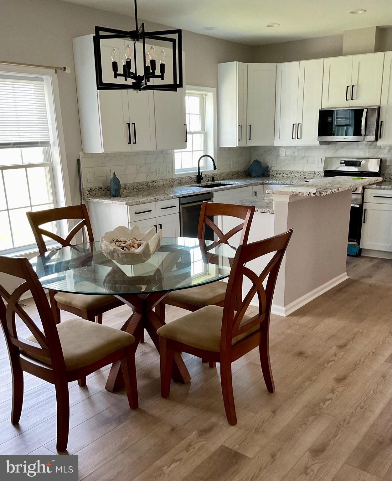 10342 Friendship Road Berlin, MD 21811 - Photo 35 of 35 a kitchen with granite countertop a dining table chairs and a wooden floor
