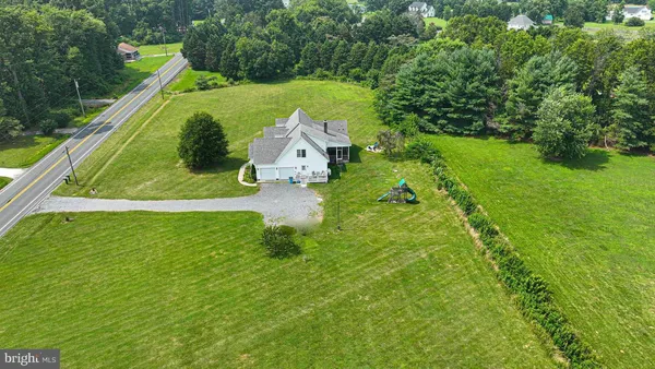 a kitchen with stainless steel appliances a refrigerator a stove a sink dishwasher and a dining table with wooden floor