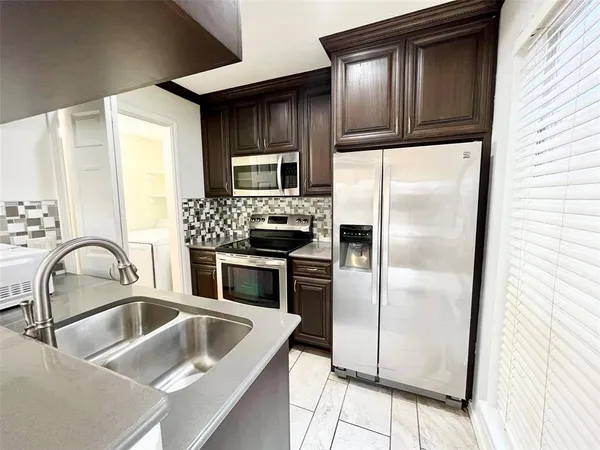 a kitchen with a refrigerator sink and microwave