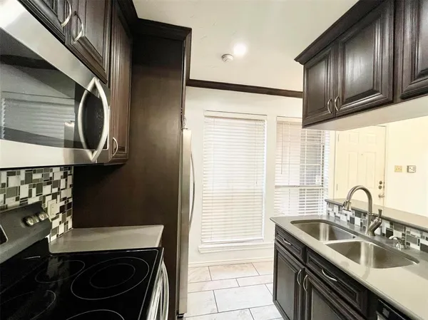 a kitchen with stainless steel appliances granite countertop a sink stove and cabinets