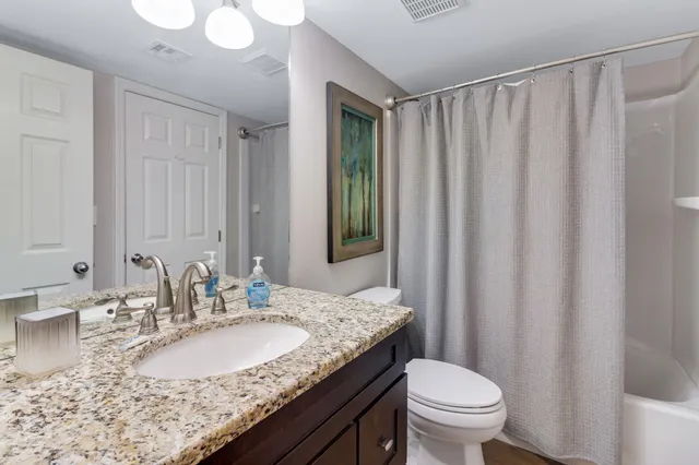 a bathroom with a granite countertop sink and a mirror with toilet