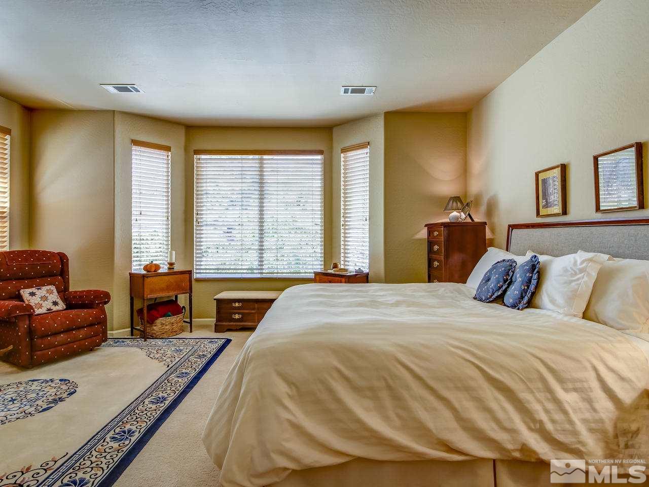 1100 Meridian Ranch Drive Reno, NV 89523 - Photo 15 of 25 a bedroom with a bed and a couch next to a window
