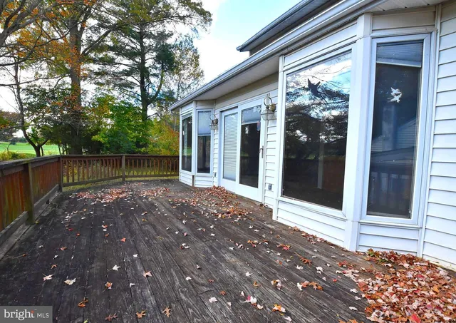 a view of deck with wooden fence and trees
