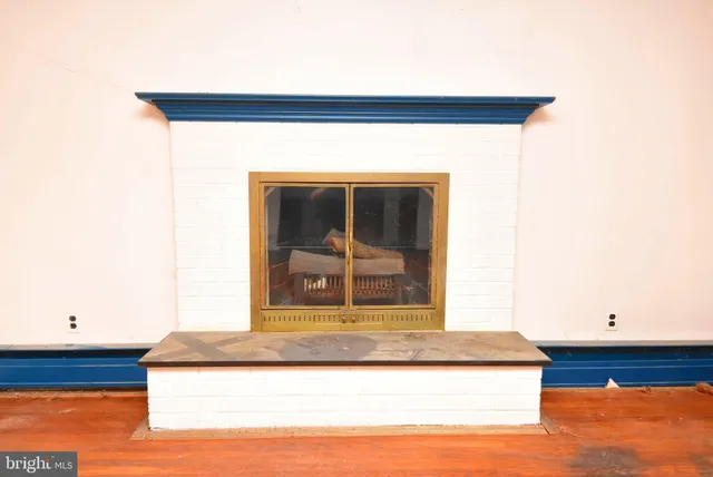 wooden floor fireplace and windows in an empty room