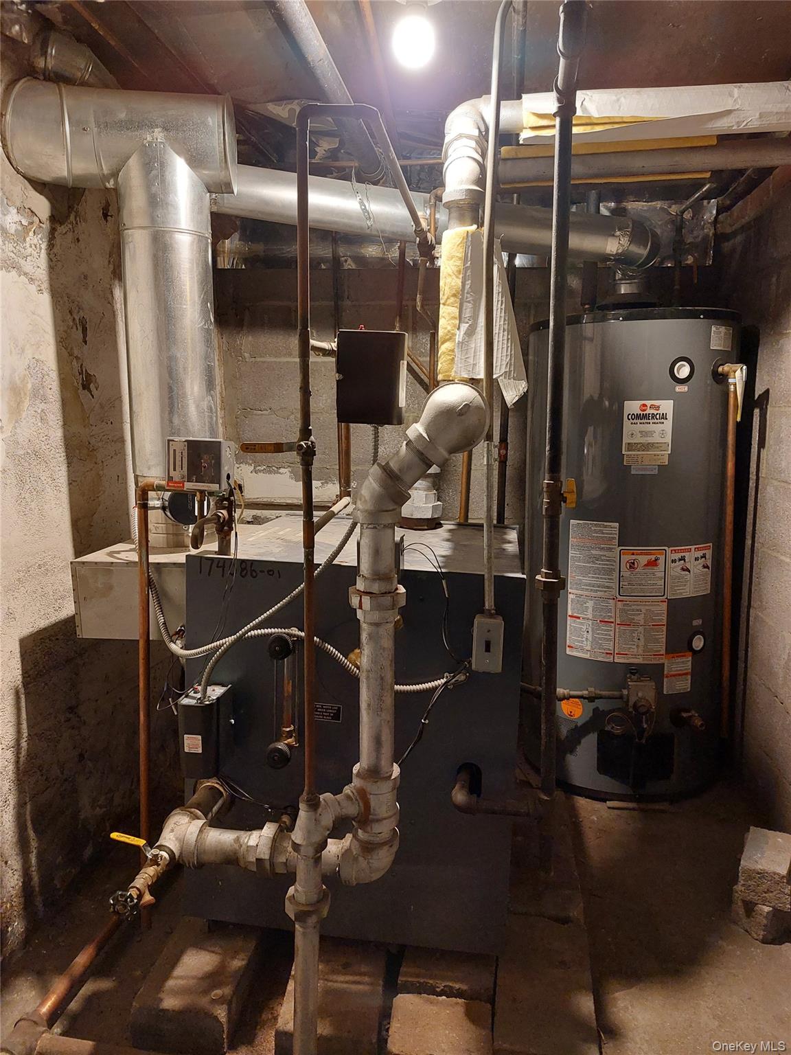 52-12 108th Street Queens, NY 11368 - Photo 8 of 8 a room with water heater and wooden cabinets