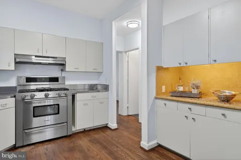 a kitchen with stainless steel appliances white cabinets and a stove top oven