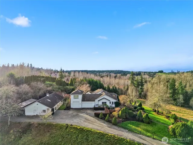 an aerial view of a house with a garden and lake view