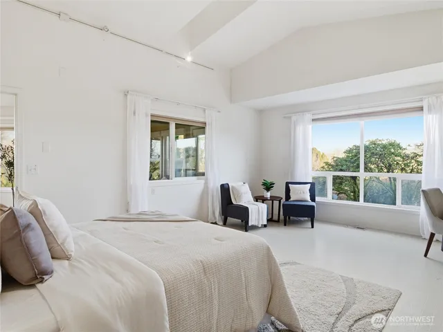 a bathroom with a granite countertop toilet a sink a mirror and a window