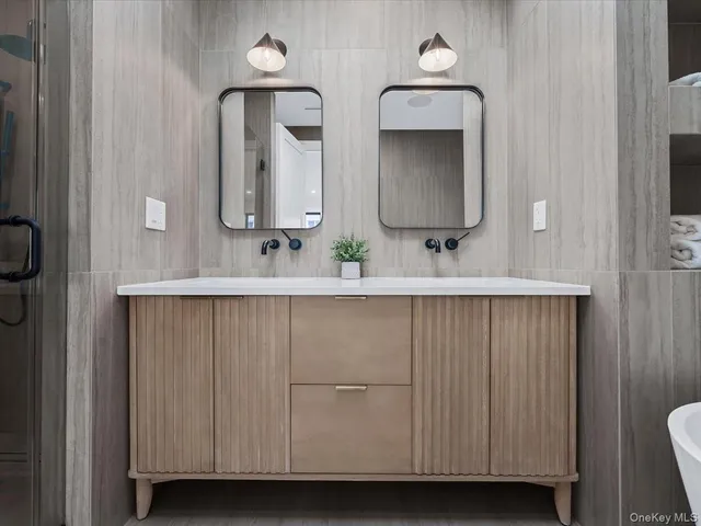 a bathroom with double vanity and a mirror