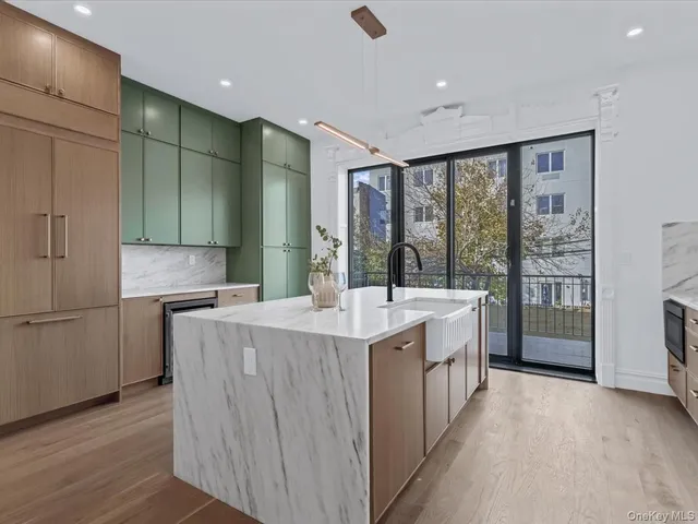 a large kitchen with a large window a sink and stainless steel appliances