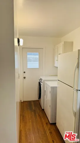 a utility room with wooden floor washer and dryer