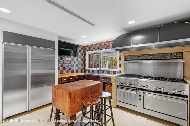 a view of a house with a big yard and palm trees