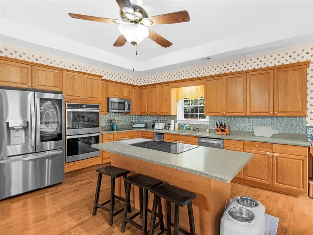a kitchen with stainless steel appliances granite countertop a sink a stove and refrigerator