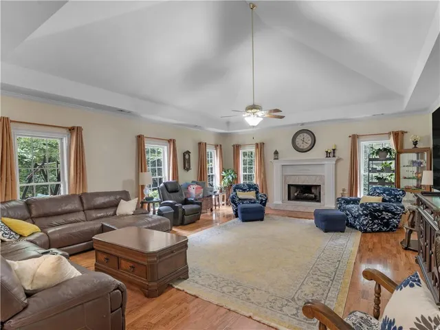a living room with furniture a fireplace and a large window