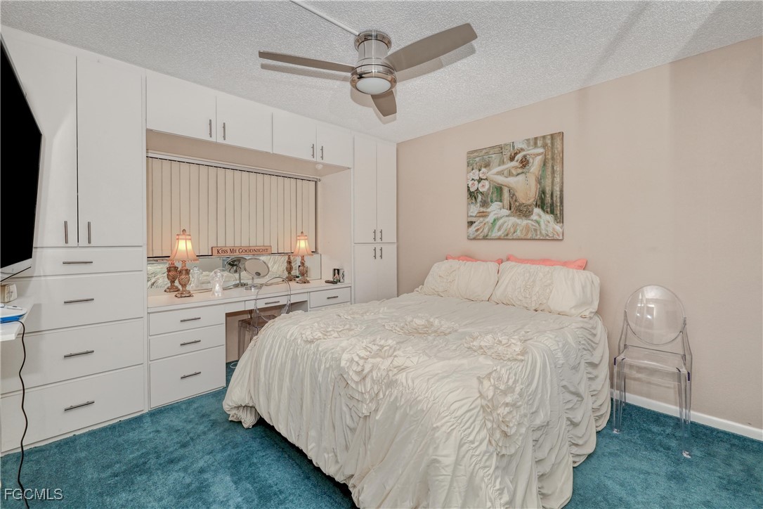 400 Lenell Road, Unit 408 Fort Myers Beach, FL 33931 - Photo 11 of 34 a spacious bedroom with a bed and a chandelier