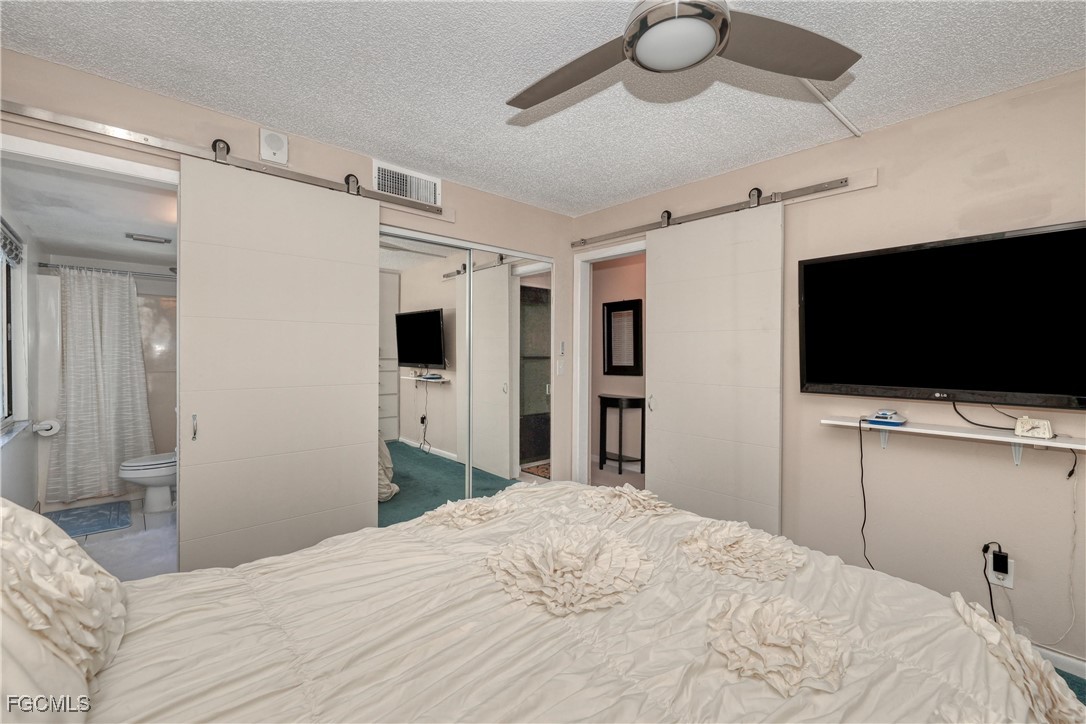 400 Lenell Road, Unit 408 Fort Myers Beach, FL 33931 - Photo 20 of 34 a bedroom with a bed and a flat screen tv