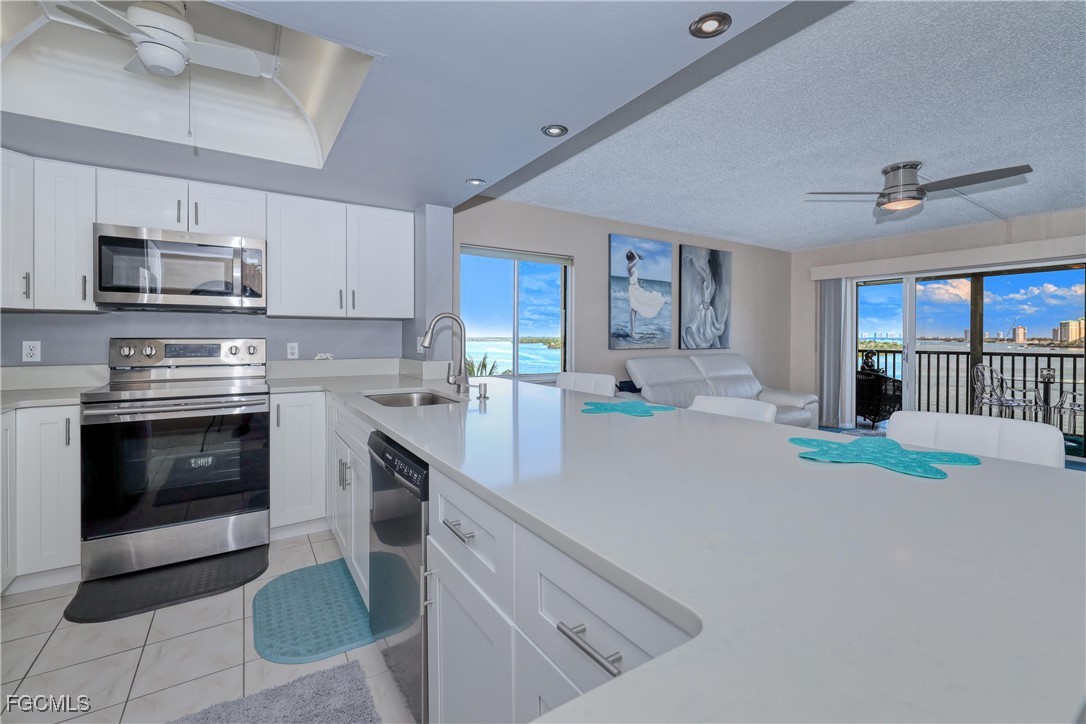 400 Lenell Road, Unit 408 Fort Myers Beach, FL 33931 - Photo 8 of 34 a kitchen with stainless steel appliances granite countertop a stove top oven a sink and a refrigerator