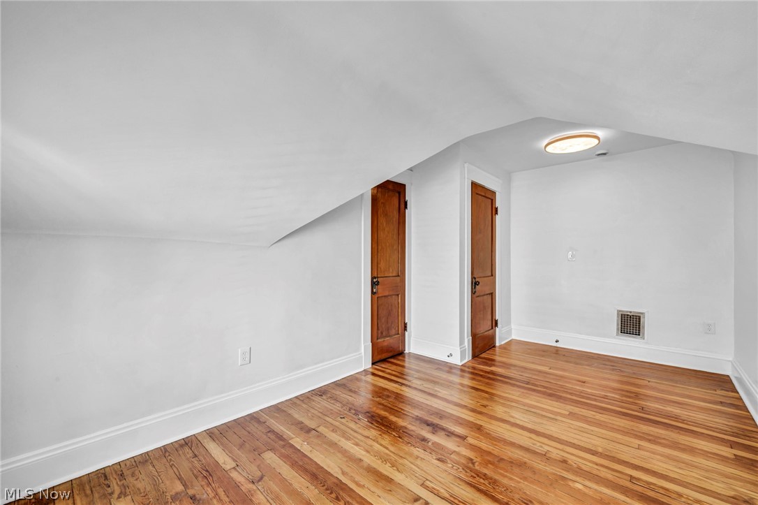 2135 Coventry Road, Unit UP Cleveland Heights, OH 44118 - Photo 30 of 38 Hardwood flooring, painted walls, two wood-paneled doors, and a ceiling-mounted light fixture