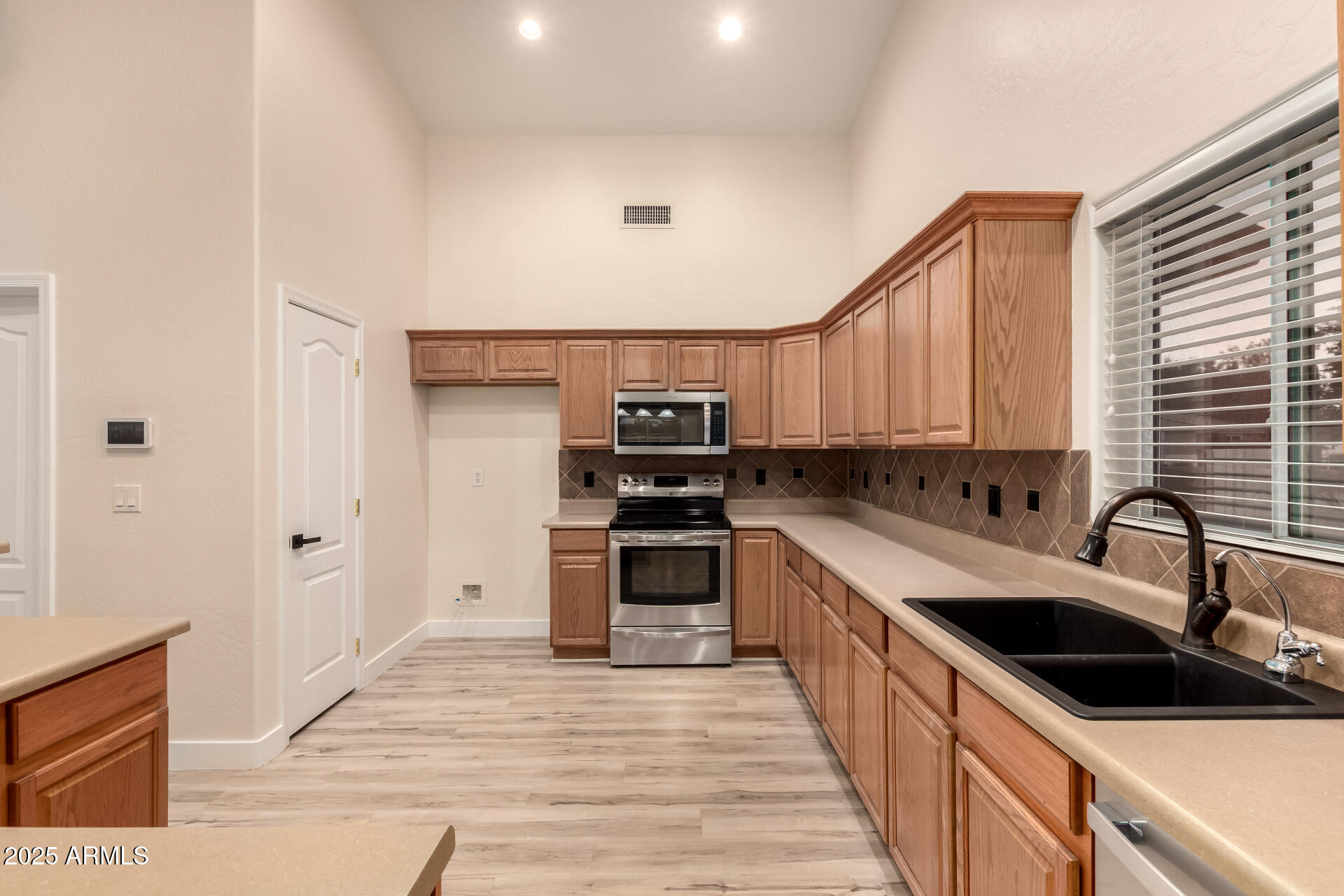 4273 South 165th Way Gilbert, AZ 85297 - Photo 16 of 56 a kitchen with stainless steel appliances granite countertop a sink and stove top oven