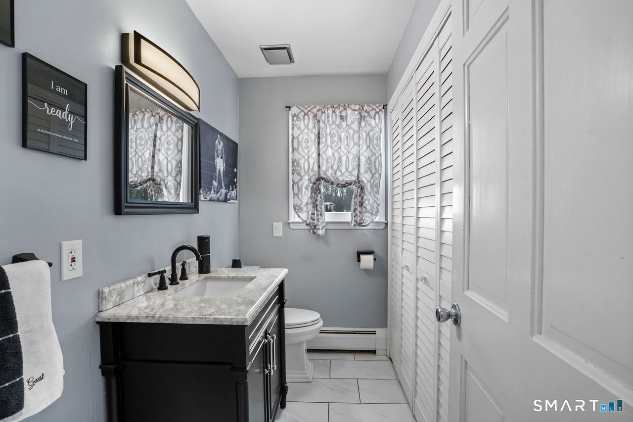 17 Moose Hill Road Trumbull, CT 06611 - Photo 19 of 40 a bathroom with a sink a toilet and shower curtain