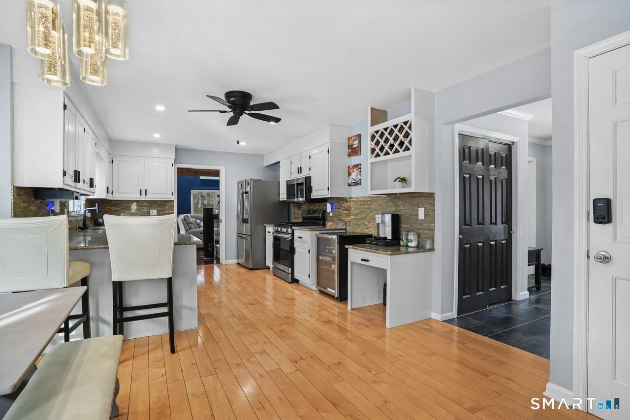 17 Moose Hill Road Trumbull, CT 06611 - Photo 10 of 40 a kitchen with stainless steel appliances kitchen island granite countertop a refrigerator a stove top oven a sink dishwasher and white cabinets with wooden floor