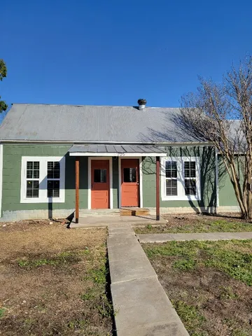a front view of a house with a yard and seating space